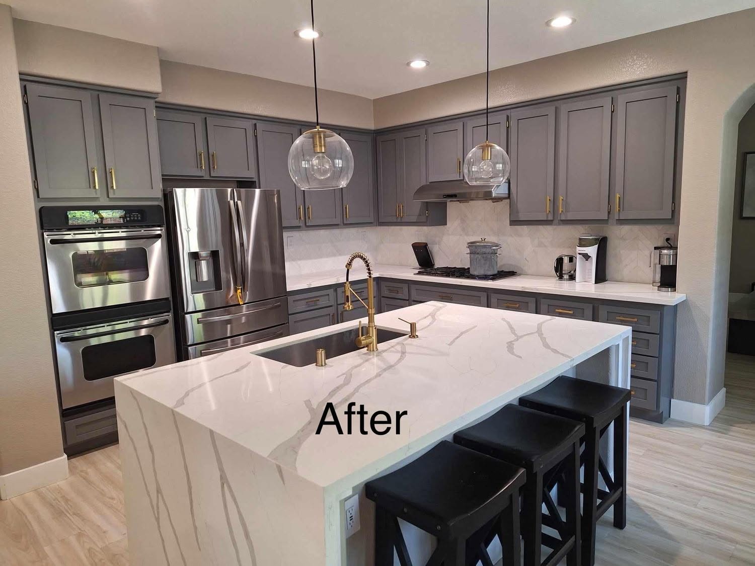 Refinished gray kitchen cabinets with marble island