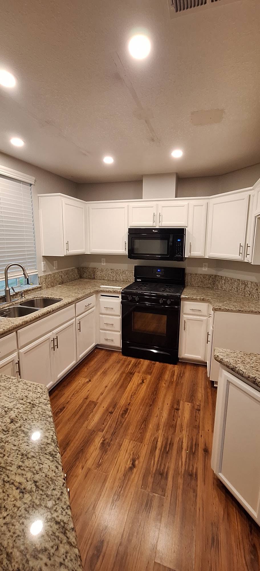 White refinished kitchen cabinets over hardwood flooring