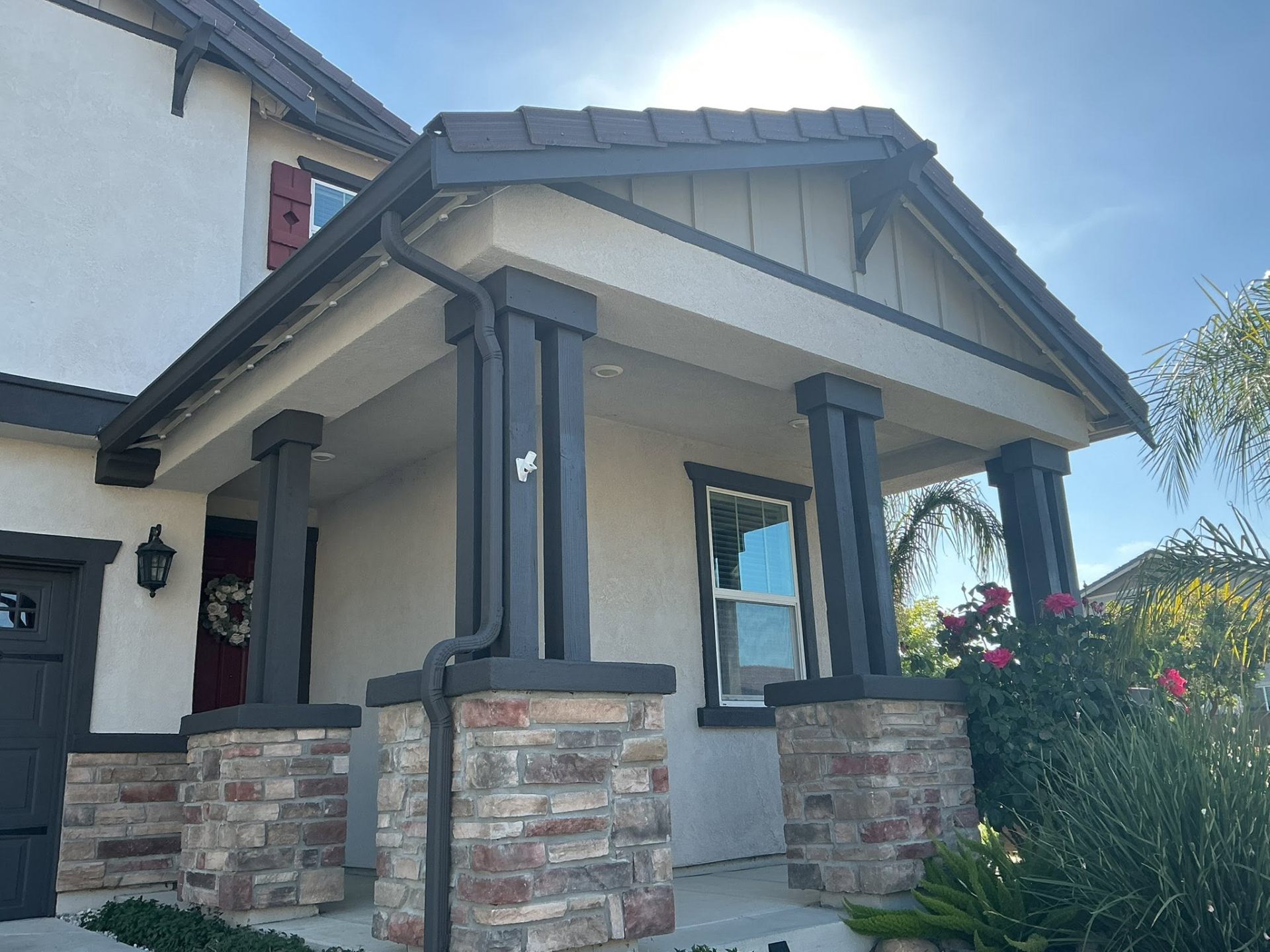 Craftsman porch with dark trim and stacked stone columns