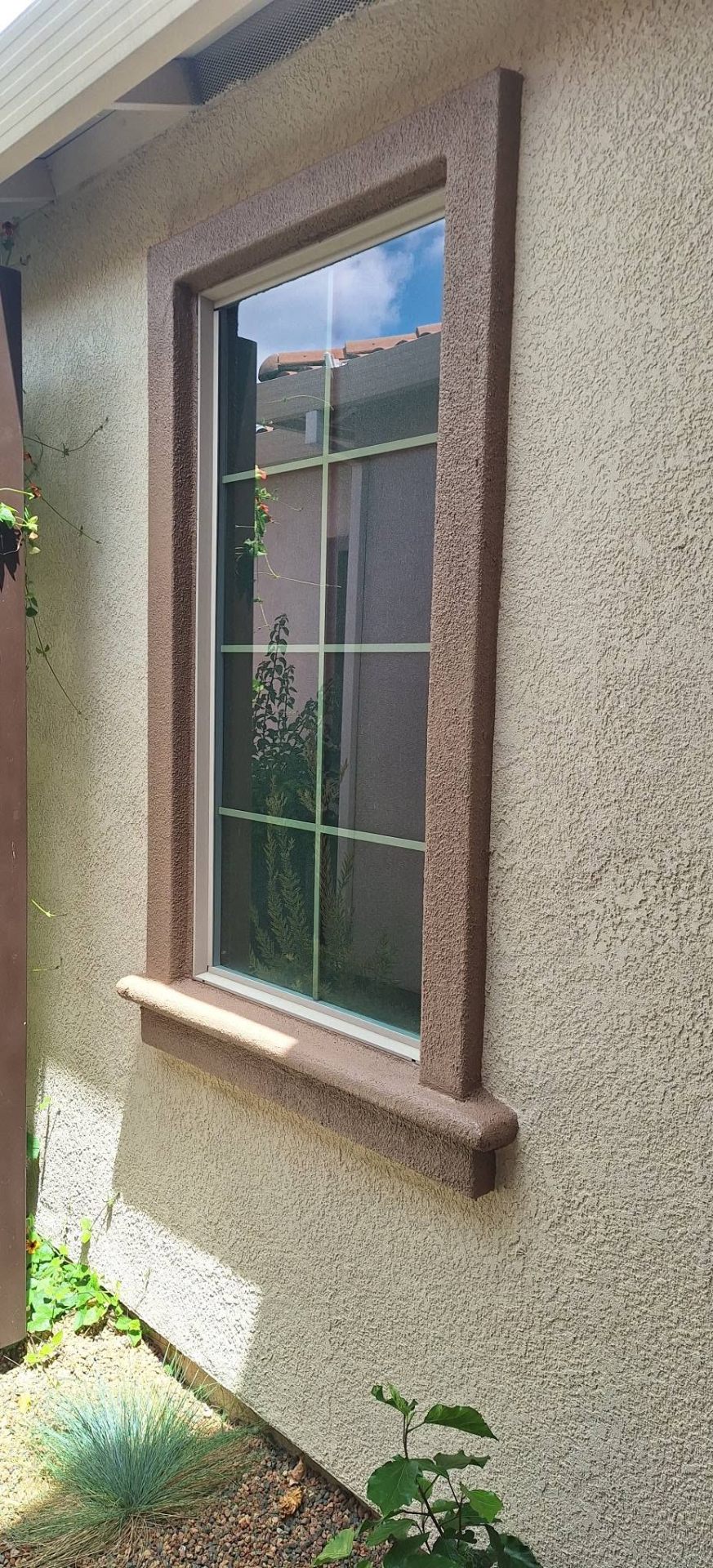 Two-tone stucco window trim repaint in mauve and cream