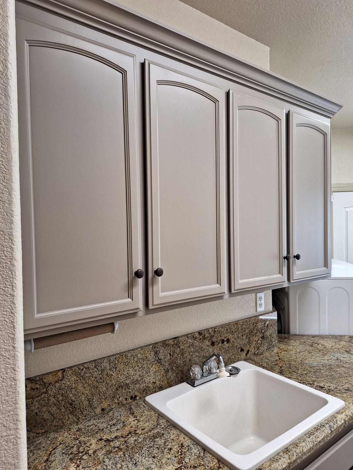 Arched cabinet doors refinished in warm gray